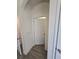 Hallway with tile flooring, arched doorway, and white doors at 16043 Scarpetta St, Winter Garden, FL 34787