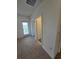 Hallway with carpet flooring, open doors and view to the outside balcony at 16043 Scarpetta St, Winter Garden, FL 34787