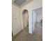 Hallway featuring an arched doorway and access to a laundry room and other living spaces at 16043 Scarpetta St, Winter Garden, FL 34787