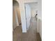 Hallway with neutral carpeting, white trim, and paneled doors leading to various rooms at 16043 Scarpetta St, Winter Garden, FL 34787