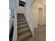 Carpeted staircase leading to the upper level with neutral colors and an art piece at 16043 Scarpetta St, Winter Garden, FL 34787