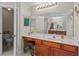 Well-lit bathroom featuring a large mirror, wooden cabinets, and a separate toilet room at 2005 Pitch Way, Kissimmee, FL 34746