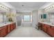 Bright bathroom features dual vanities, soaking tub, a walk-in shower, and neutral tile flooring at 2005 Pitch Way, Kissimmee, FL 34746