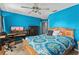 A bedroom with a ceiling fan, desk, and vibrant blue walls at 2005 Pitch Way, Kissimmee, FL 34746