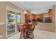 Eat-in kitchen featuring wood cabinetry, stainless appliances, and access to a screened patio at 2005 Pitch Way, Kissimmee, FL 34746