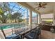 Screened-in patio with dining table, built-in grill, and view of the swimming pool and lush landscaping at 2005 Pitch Way, Kissimmee, FL 34746