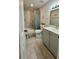 Well-lit bathroom featuring a shower with curtain, grey vanity with white countertop, and decorative accents at 2350 Valley Dr, Apopka, FL 32703