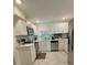 Bright kitchen features stainless steel appliances, white cabinets and view to back yard at 2350 Valley Dr, Apopka, FL 32703