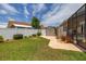 Nicely landscaped backyard with a shed, white fence, lush lawn, and vibrant flower pots, enhancing outdoor appeal at 239 King George Dr, Davenport, FL 33837
