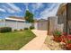 Well-maintained backyard with a garden shed, lush lawn, and walkway, accented by vibrant potted flowers at 239 King George Dr, Davenport, FL 33837