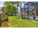 Lush backyard with a screened pool area, mature trees, well-kept lawn, and inviting lounge chairs at 239 King George Dr, Davenport, FL 33837