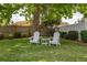 Backyard with lush lawn and mature tree providing shade, with two Adirondack chairs at 239 King George Dr, Davenport, FL 33837