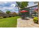 Spacious backyard featuring a stone patio with outdoor seating and a screened-in pool, perfect for entertaining at 239 King George Dr, Davenport, FL 33837