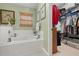 The bathroom features a tub, window with blind, and a walk-in closet with ample storage at 239 King George Dr, Davenport, FL 33837