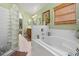 Bright bathroom featuring a soaking tub, a glass block shower, and double vanity at 239 King George Dr, Davenport, FL 33837