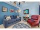 Cozy bedroom with blue walls, complemented by a sofa and a comfortable red armchair at 239 King George Dr, Davenport, FL 33837