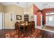 The dining area features a six-seat wooden table with a red area rug and a view of the front door at 239 King George Dr, Davenport, FL 33837