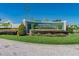 Landscaped entrance to Regency Place features manicured greenery and colorful flowerbeds at 239 King George Dr, Davenport, FL 33837