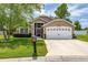 Charming one-story home featuring a well-manicured lawn and an attached two-car garage at 239 King George Dr, Davenport, FL 33837