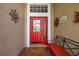 Inviting front entry featuring a red door, tiled porch, and decorative wall art at 239 King George Dr, Davenport, FL 33837