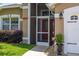 Inviting front porch features a screened entryway and a bright red front door for added curb appeal at 239 King George Dr, Davenport, FL 33837