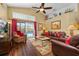 Bright living room with vaulted ceiling, fan, and a sliding glass door leading to a pool area at 239 King George Dr, Davenport, FL 33837