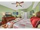 Comfortable main bedroom offers a ceiling fan, art work, and a view of a dresser and the entrance to the bathroom at 239 King George Dr, Davenport, FL 33837