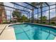A refreshing screened-in pool with inviting patio furniture and a lovely landscaped backyard at 239 King George Dr, Davenport, FL 33837