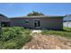 Backyard view features a sliding glass door and patchy lawn at 2451 Quail Run N Blvd, Kissimmee, FL 34744
