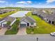 Beautiful home featuring a paver driveway, solar panels, lush landscaping, and a serene lake view at 249 Bella Cortina Dr, Kissimmee, FL 34759