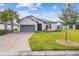 Charming single-story home with lush lawn, beautiful landscaping, and brick driveway at 249 Bella Cortina Dr, Kissimmee, FL 34759