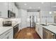Bright, eat-in kitchen with stainless steel appliances, white cabinets, and hardwood floors at 249 Bella Cortina Dr, Kissimmee, FL 34759