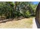 The shady backyard features a mature tree and a wooden bench at 2560 Greenwood Dr, Kissimmee, FL 34744