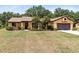 Charming one-story home with a well-manicured lawn, mature trees, and a tile roof at 2560 Greenwood Dr, Kissimmee, FL 34744