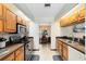 Galley kitchen with wood cabinets and stainless steel appliances overlooking a dining area at 2560 Greenwood Dr, Kissimmee, FL 34744