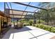 Spacious screened-in patio with an outdoor dining area and lush greenery at 2560 Greenwood Dr, Kissimmee, FL 34744