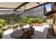 Screened-in patio with an outdoor dining set, jacuzzi, and lush landscaping at 2560 Greenwood Dr, Kissimmee, FL 34744