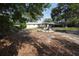 A lush backyard setting with trees, landscaping and fire pit area at 26 College Dr, Babson Park, FL 33827