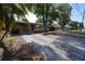 Charming single-story home with a driveway, mature trees, and red shutters for added curb appeal at 26 College Dr, Babson Park, FL 33827