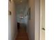 Long hallway with wood floors leading to a red chair and partially visible door at 26 College Dr, Babson Park, FL 33827
