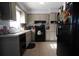 Efficient kitchen featuring tile floors, black appliances, and cabinets with ample counter space at 26 College Dr, Babson Park, FL 33827