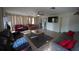 Spacious living room with tile floors, neutral colors, a ceiling fan, and access to the kitchen at 26 College Dr, Babson Park, FL 33827