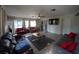 Spacious living room with tile floors, neutral colors, a ceiling fan, and access to the kitchen at 26 College Dr, Babson Park, FL 33827
