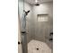Contemporary shower with stone floor and wall niche, featuring matte black hardware at 2943 Annalee Rd, St Cloud, FL 34771