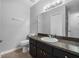 Bathroom featuring a vanity, toilet, and a mirror with vanity lighting at 301 Lake Ned Rd, Winter Haven, FL 33884