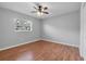 This bedroom offers hardwood floors, a ceiling fan, a window and neutral paint at 301 Lake Ned Rd, Winter Haven, FL 33884
