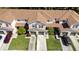 This aerial showcases a townhouse with a garage, driveway, landscaping, green lawns, and some cars parked at 3071 Seaview Castle Dr, Kissimmee, FL 34746