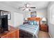 This cozy bedroom features a ceiling fan, a comfy-looking bed with pillows, and matching nightstands with lamps at 3071 Seaview Castle Dr, Kissimmee, FL 34746