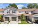 Inviting two-story townhouse with well-manicured landscaping, attached garages, and neutral stucco exterior at 3071 Seaview Castle Dr, Kissimmee, FL 34746