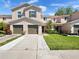 Well-maintained townhouse with a two-car garage, green lawn, landscaping, and a driveway at 3071 Seaview Castle Dr, Kissimmee, FL 34746